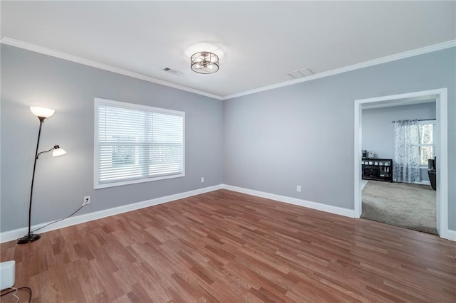 spare room featuring crown molding and hardwood / wood-style floors