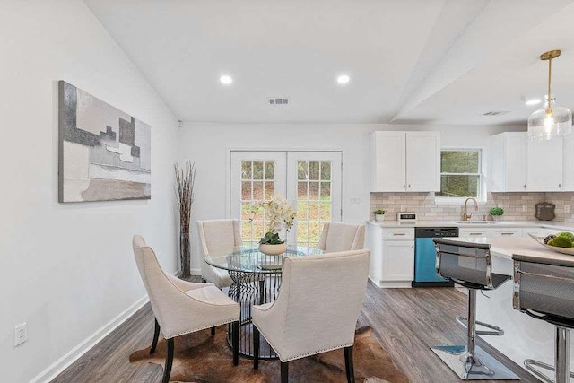 dining room with vaulted ceiling, sink, dark wood-type flooring, and french doors