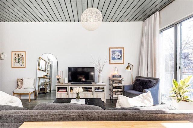 living room featuring wood ceiling and finished concrete floors