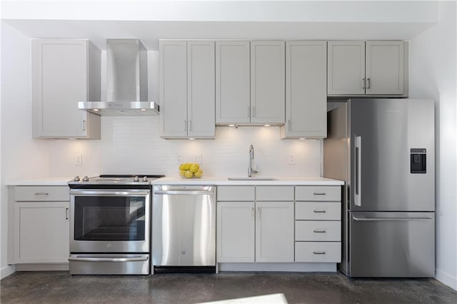 kitchen with a sink, stainless steel appliances, light countertops, and wall chimney range hood