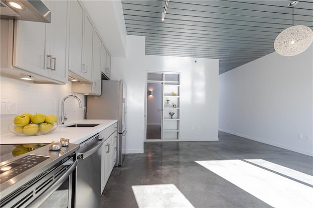 kitchen featuring baseboards, light countertops, exhaust hood, stainless steel appliances, and a sink