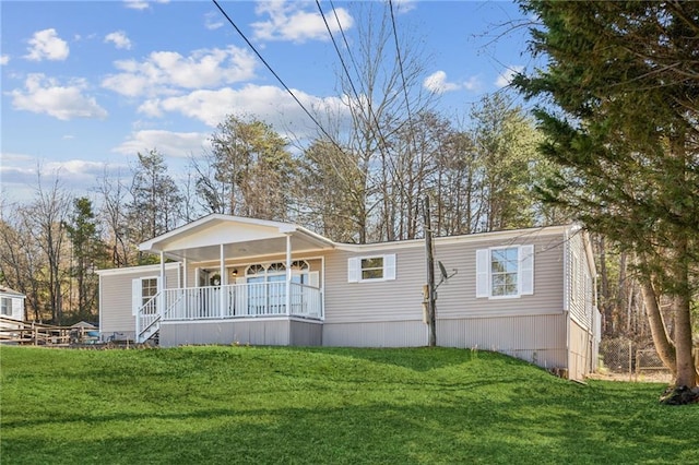 rear view of house featuring a porch and a yard