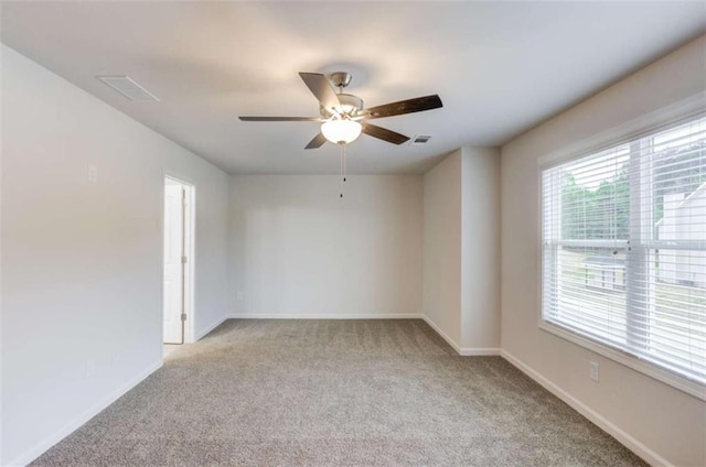 carpeted spare room with ceiling fan