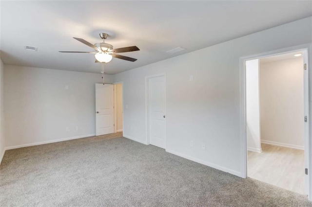 empty room with ceiling fan and light colored carpet