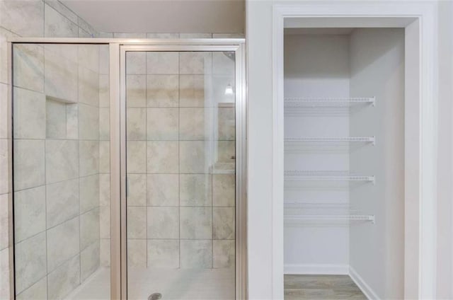 bathroom with an enclosed shower and hardwood / wood-style flooring