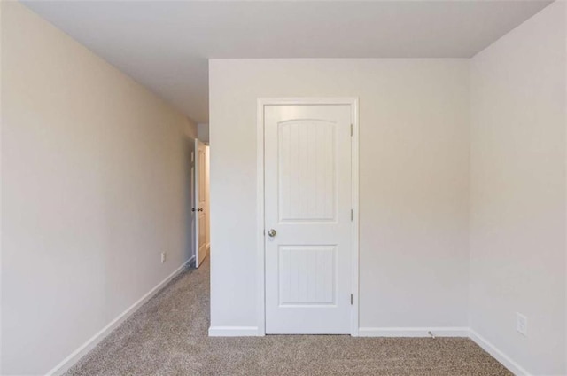 spare room featuring light colored carpet