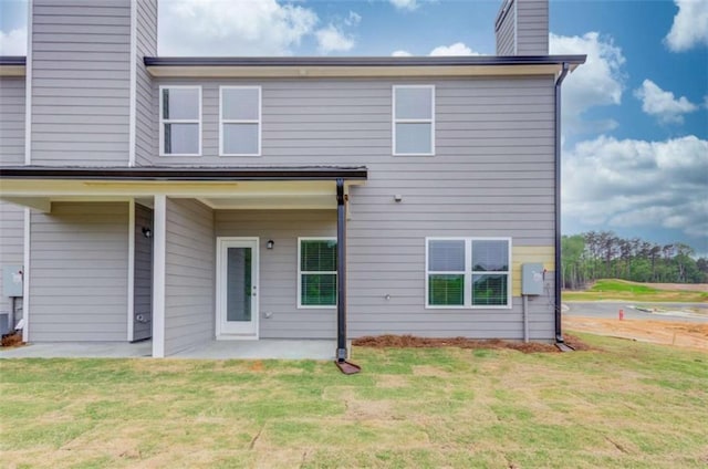 back of property featuring a patio area and a yard