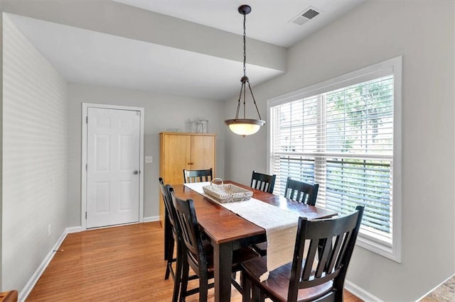 dining area with light wood-type flooring and baseboards
