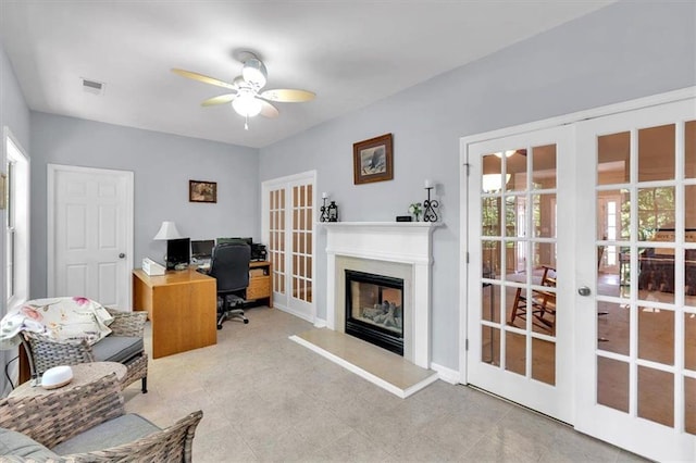 office space featuring french doors, a ceiling fan, and a glass covered fireplace