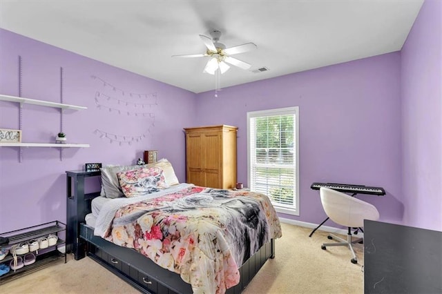 bedroom featuring light colored carpet, a ceiling fan, and baseboards