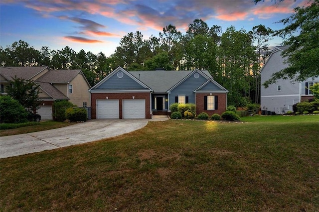 ranch-style house with a garage, brick siding, driveway, and a front yard