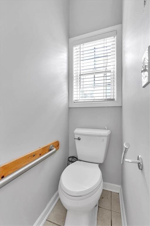 bathroom with tile patterned flooring, baseboards, and toilet
