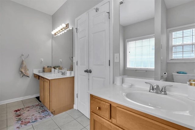 full bathroom with vanity, tile patterned flooring, and baseboards