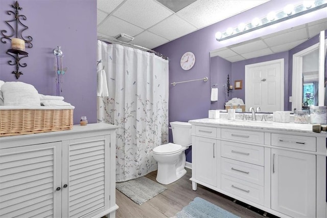 full bath featuring a paneled ceiling, wood finished floors, toilet, vanity, and a shower with curtain