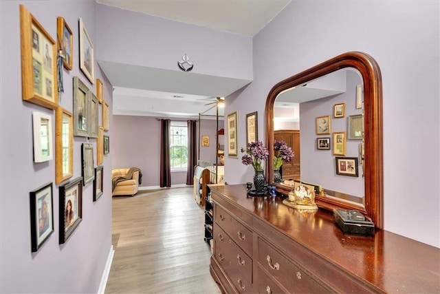 hall with light wood finished floors and baseboards
