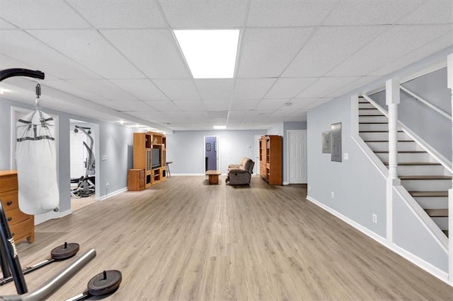 workout room with a paneled ceiling, wood finished floors, and baseboards
