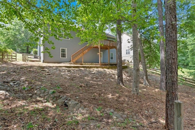 view of yard featuring stairs, a deck, and fence