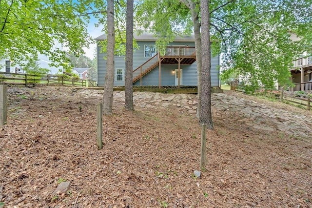 view of yard with a wooden deck, stairway, and fence