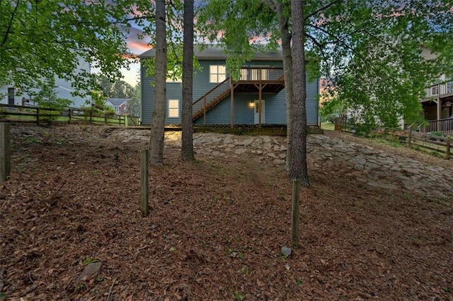 view of yard with a deck, fence, and stairs