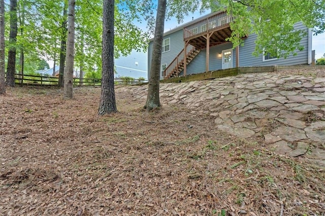 view of yard featuring a deck, stairs, fence, and a patio area