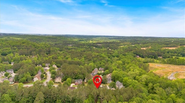 aerial view of property and surrounding area with a heavily wooded area