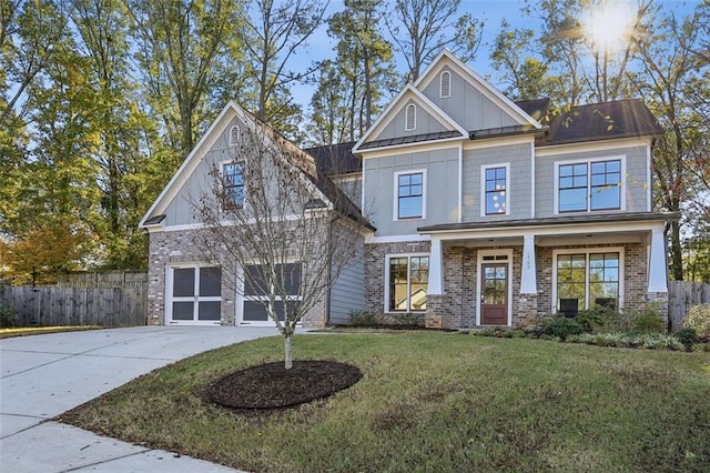 craftsman inspired home featuring covered porch, a front yard, and a garage