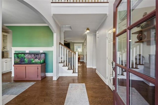 foyer entrance with dark wood-type flooring and crown molding