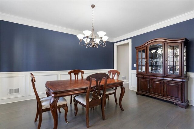 dining area featuring a notable chandelier, dark wood-type flooring, and ornamental molding