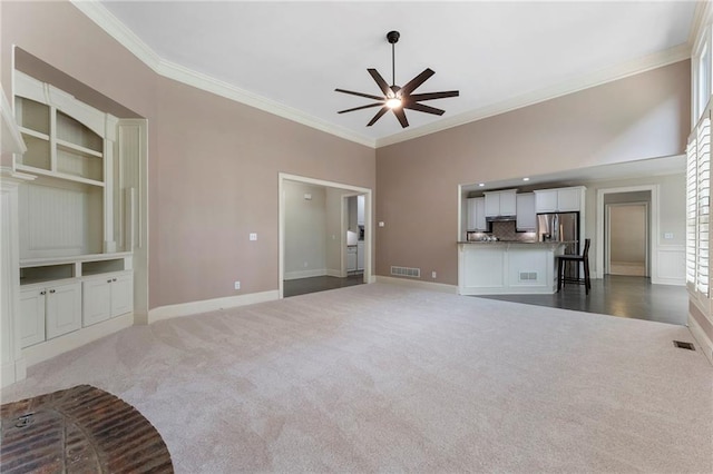 183 Applewood Ln, Acworth, GA 30101 - unfurnished living room featuring dark colored carpet, ceiling fan, ornamental molding, baseboards, and built in features
