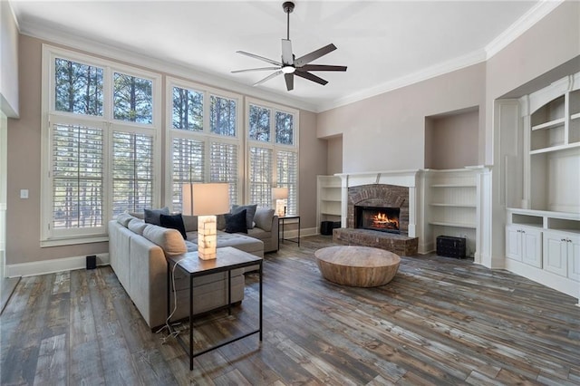 living room featuring dark wood-type flooring, ceiling fan, ornamental molding, and a fireplace