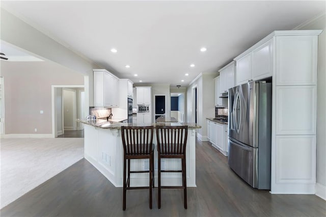 183 Applewood Ln, Acworth, GA 30101 - kitchen with appliances with stainless steel finishes, a peninsula, dark wood-style flooring, recessed lighting, and white cabinetry