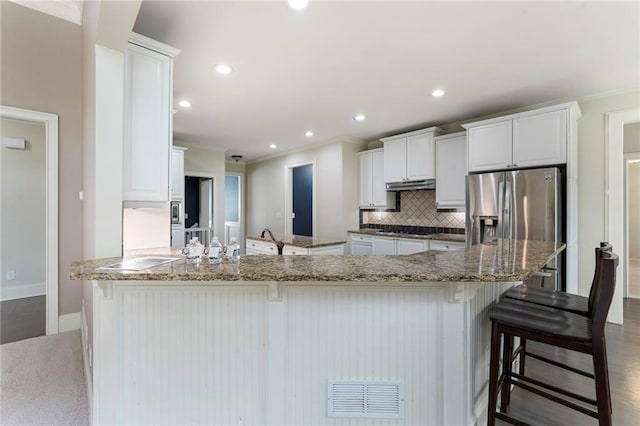 183 Applewood Ln, Acworth, GA 30101 - kitchen with ornamental molding, under cabinet range hood, black cooktop, backsplash, and stainless steel fridge with ice dispenser