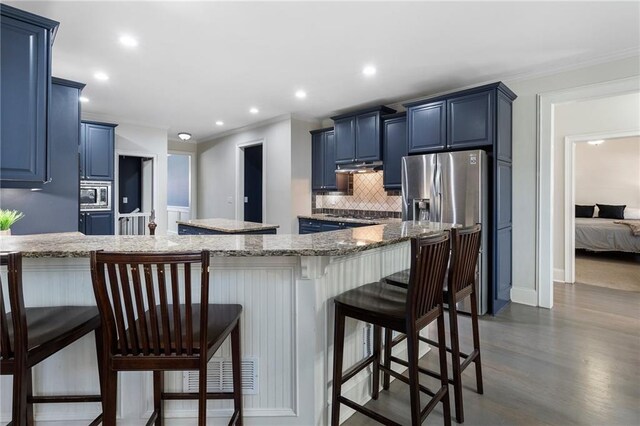 kitchen with blue cabinets, stainless steel appliances, and a breakfast bar