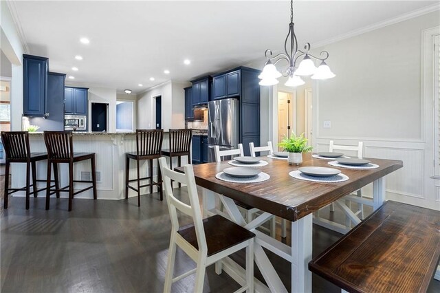 dining room with dark hardwood / wood-style flooring, ornamental molding, and a chandelier