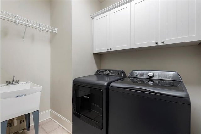 washroom featuring cabinets, light tile patterned flooring, washer and dryer, and sink