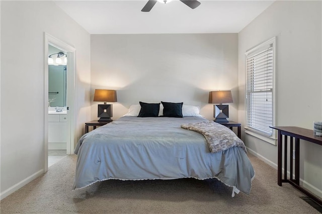 bedroom with ensuite bath, light colored carpet, and ceiling fan