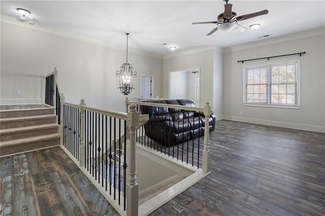 staircase featuring crown molding, ceiling fan with notable chandelier, and hardwood / wood-style floors