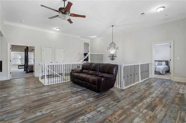 living room with crown molding, dark hardwood / wood-style flooring, and ceiling fan with notable chandelier