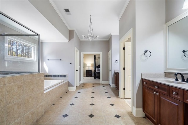 bathroom with an inviting chandelier, ornamental molding, vanity, tiled tub, and tile patterned flooring