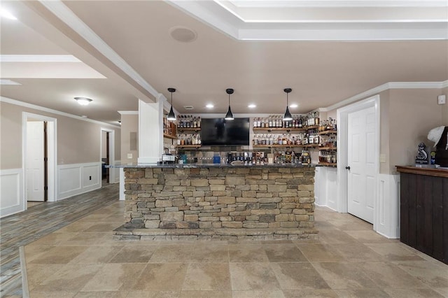 bar with ornamental molding and decorative light fixtures