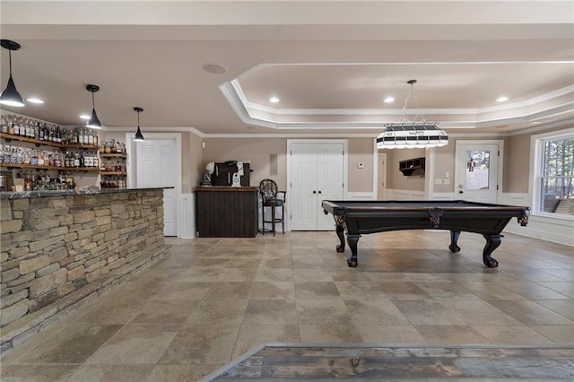 game room with a raised ceiling, crown molding, pool table, and bar area