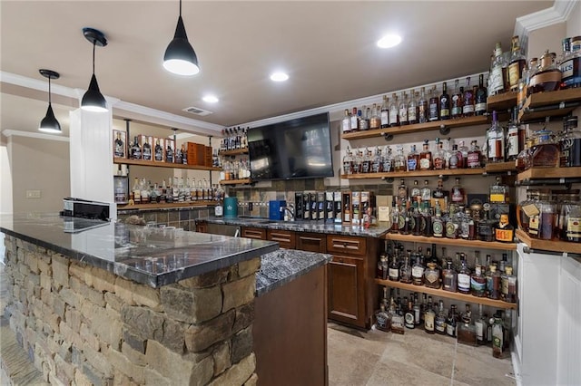 bar with ornamental molding, sink, dark stone countertops, and decorative light fixtures