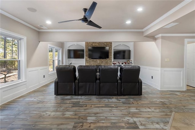 home theater room with crown molding, ceiling fan, and dark wood-type flooring