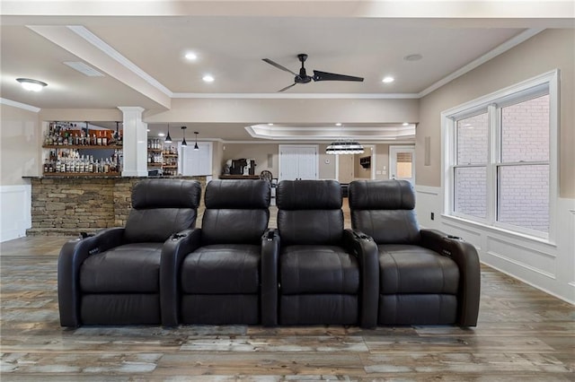 home theater featuring ceiling fan, ornamental molding, hardwood / wood-style floors, and decorative columns