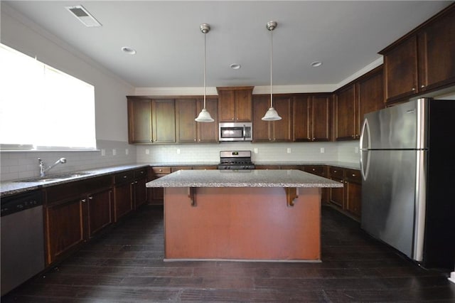 2307 Overlook Ave, Lithonia, GA 30058 - kitchen featuring stainless steel appliances, a sink, a center island, a breakfast bar, and hanging light fixtures