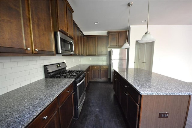 2307 Overlook Ave, Lithonia, GA 30058 - kitchen featuring appliances with stainless steel finishes, a kitchen island, decorative backsplash, dark stone counters, and dark wood finished floors