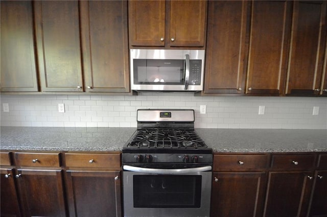 2307 Overlook Ave, Lithonia, GA 30058 - kitchen featuring appliances with stainless steel finishes, tasteful backsplash, and dark stone countertops