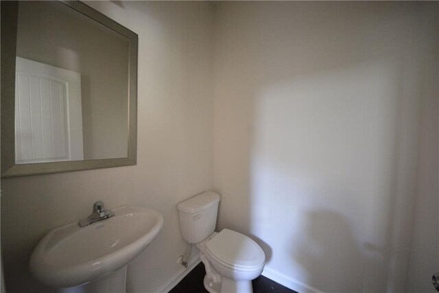 2307 Overlook Ave, Lithonia, GA 30058 - half bathroom featuring baseboards, toilet, and a sink