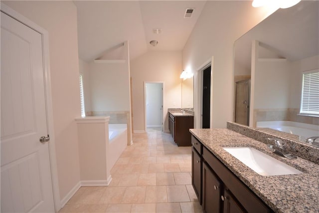 2307 Overlook Ave, Lithonia, GA 30058 - bathroom featuring a shower stall, two vanities, a bath, lofted ceiling, and baseboards
