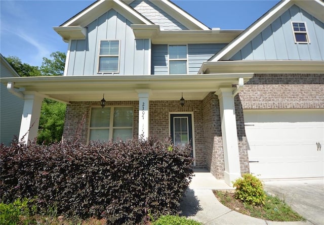 2307 Overlook Ave, Lithonia, GA 30058 - view of front facade with board and batten siding, brick siding, covered porch, and an attached garage